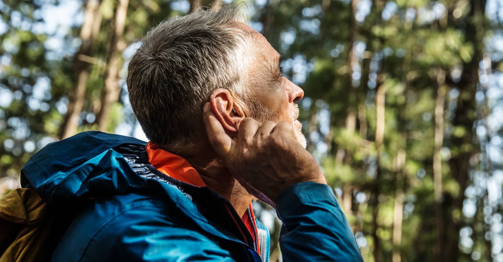 18.01 Widex EVOKE Man adjusting hearings aids in forest environment (1)